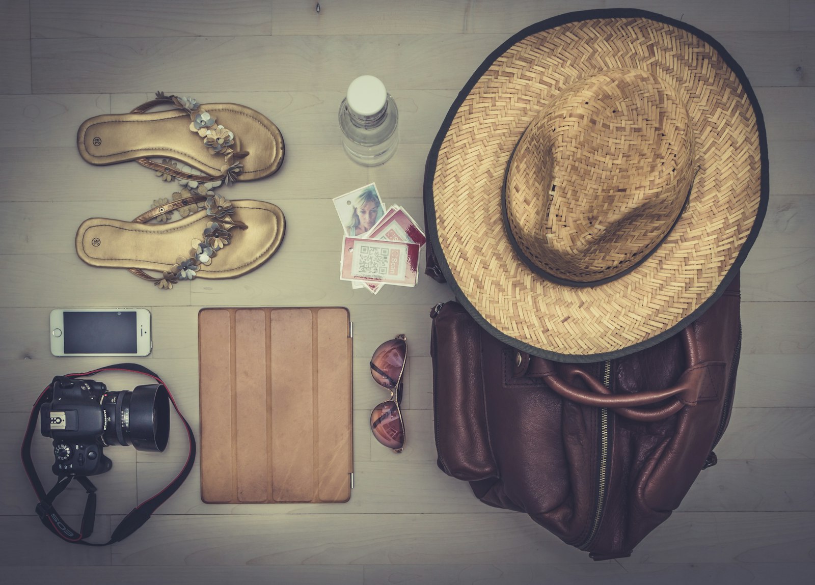Editorial flat-lay of travel essentials on a wooden surface