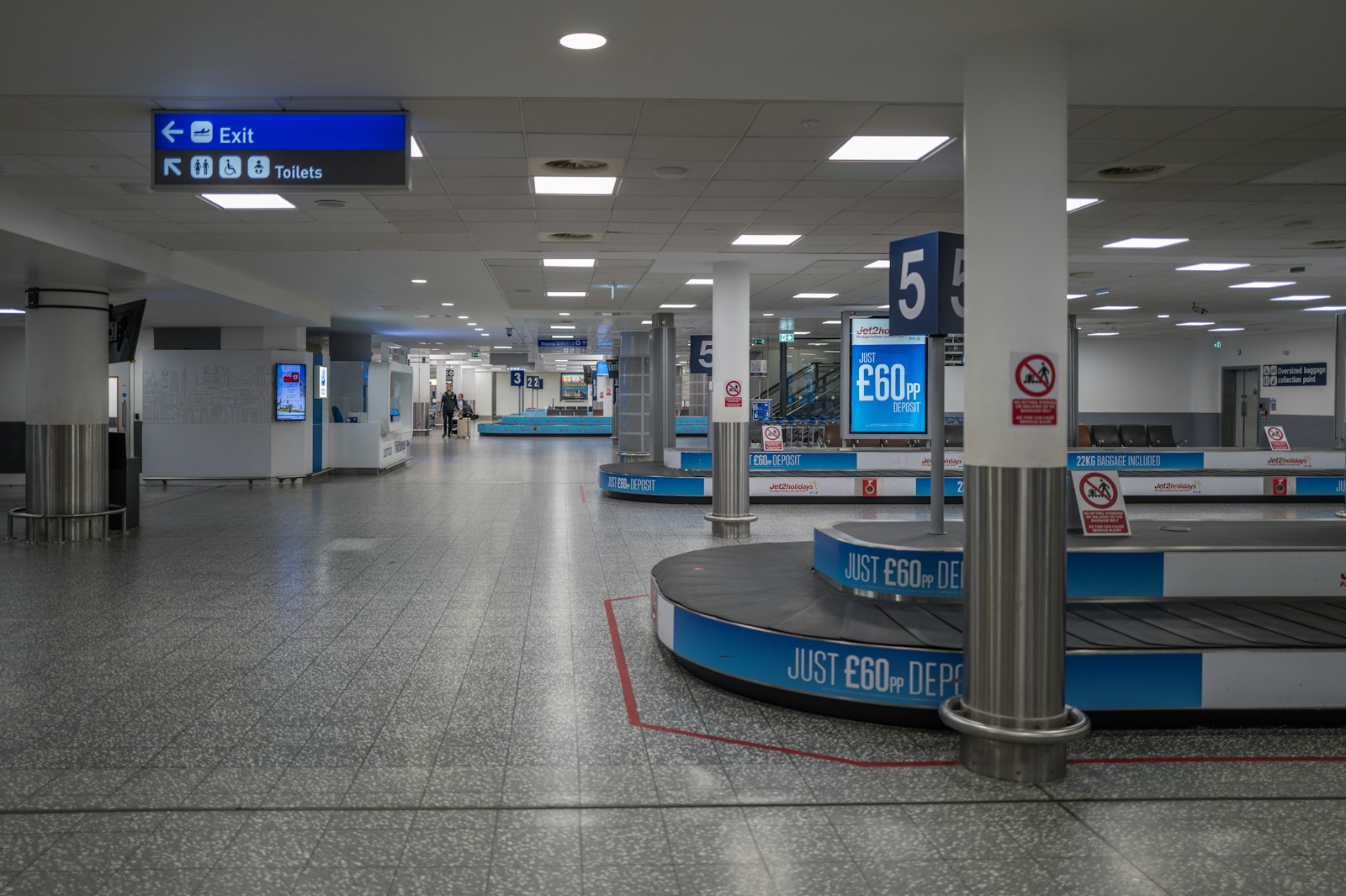 An empty airport baggage carousel under fluorescent light