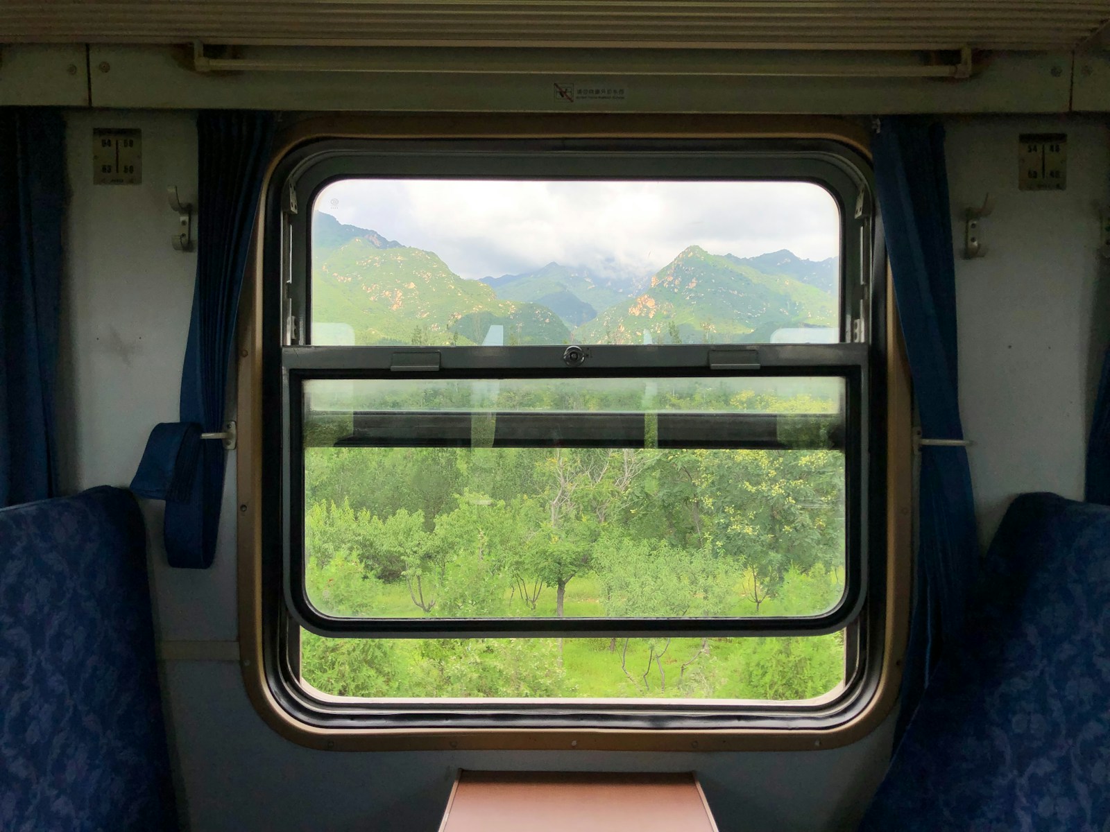 Empty seats inside a modern European train with countryside visible through the window